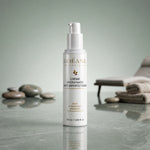 Crème Hydratante Anti-imperfections ODÉANE, 50 ml, sur un plan de pierre réfléchissant, près de galets et de serviettes sur fond vert pâle.