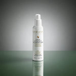 Flacon de Crème Hydratante Anti-imperfections ODÉANE, 50 ml, sur une surface réfléchissante et un fond gris-vert éclairé au centre.
