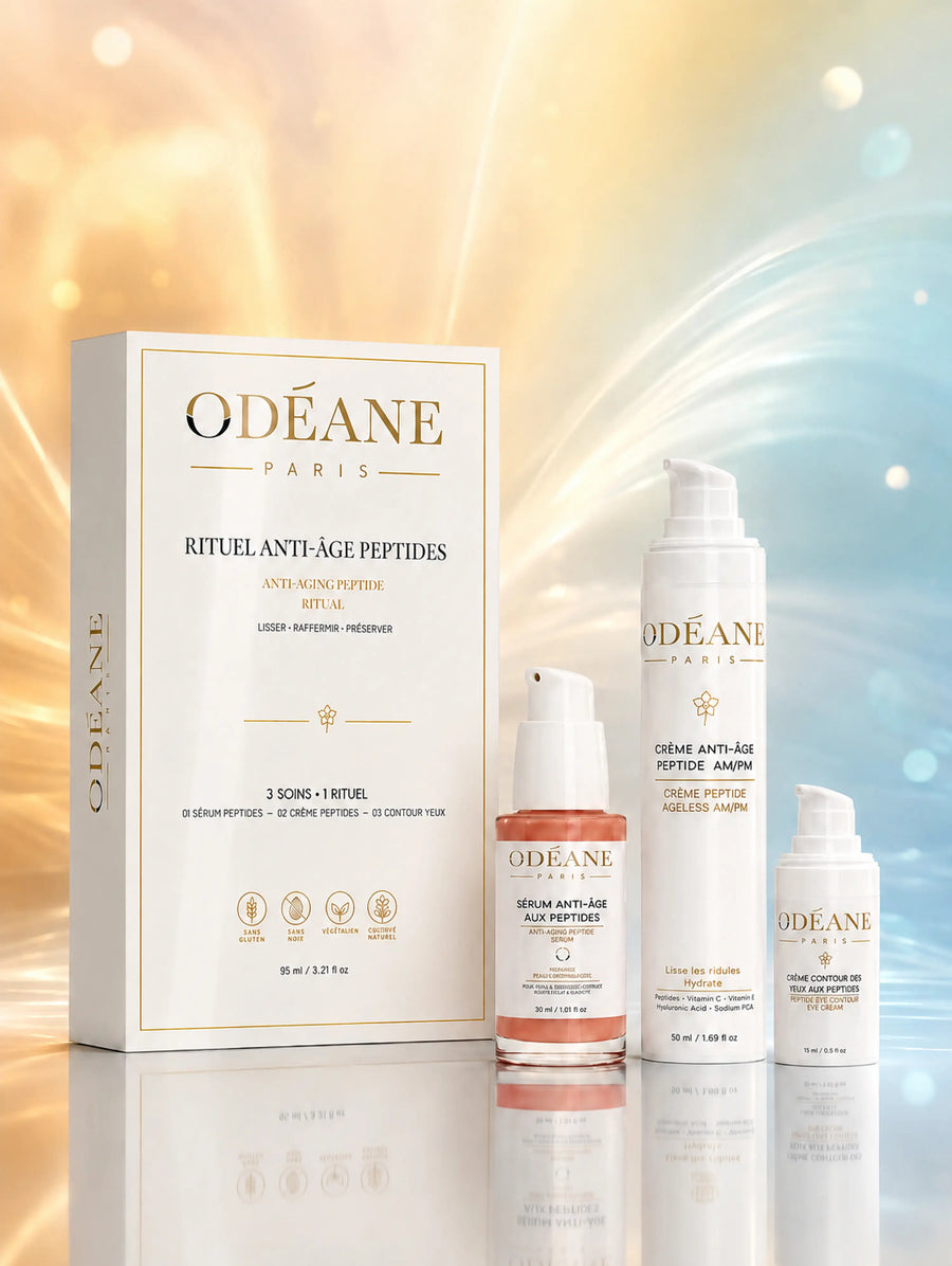 Coffret Anti-Âge ODÉANE et ses trois soins aux peptides sur une surface réfléchissante et un fond bleu et doré lumineux.