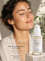 Portrait d'une femme aux yeux fermés, avec flacon de Sérum Correcteur de Taches ODÉANE, 30 ml, et texte de présentation.